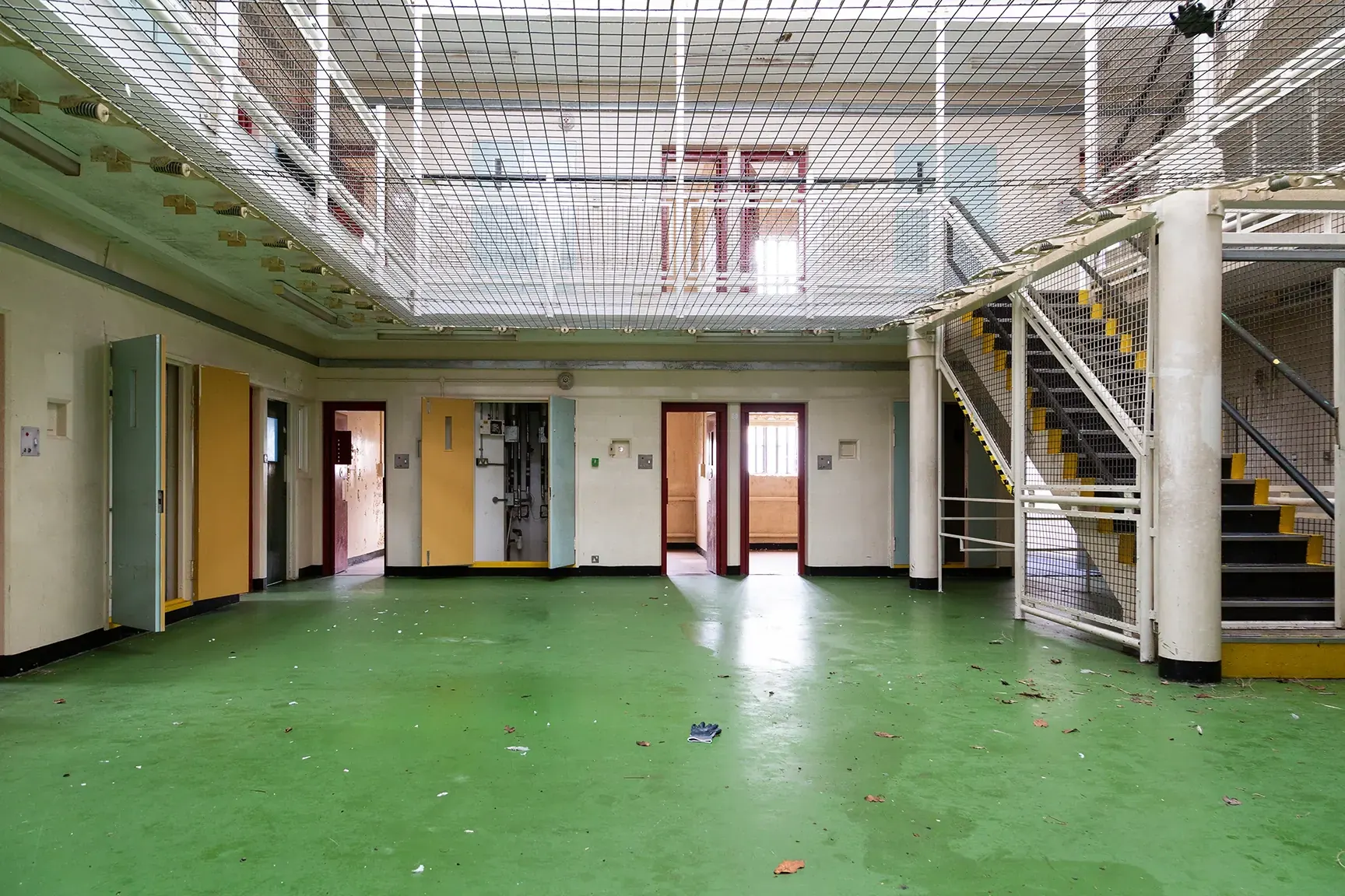Multi-level prison wing with cell galleries, walkways and safety netting across the atrium