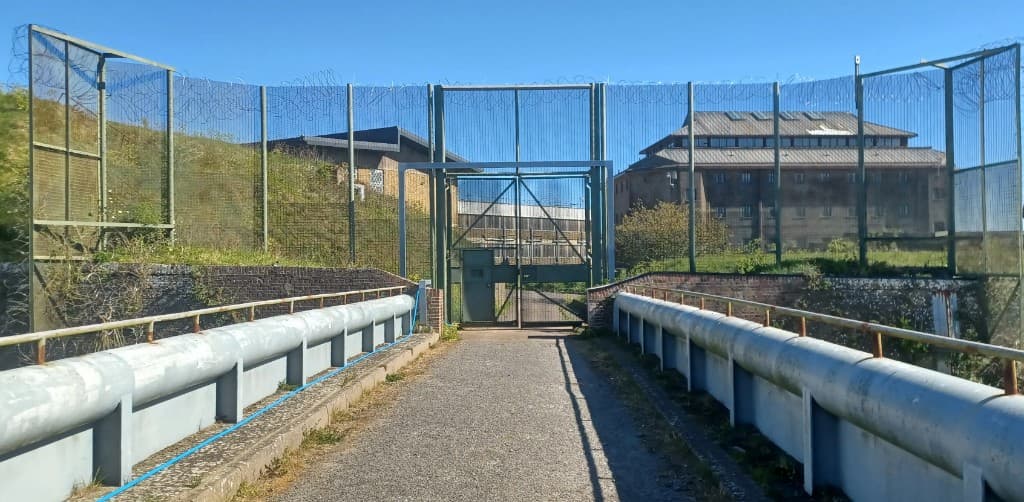 Paved bridge leading to green security gate over the moat